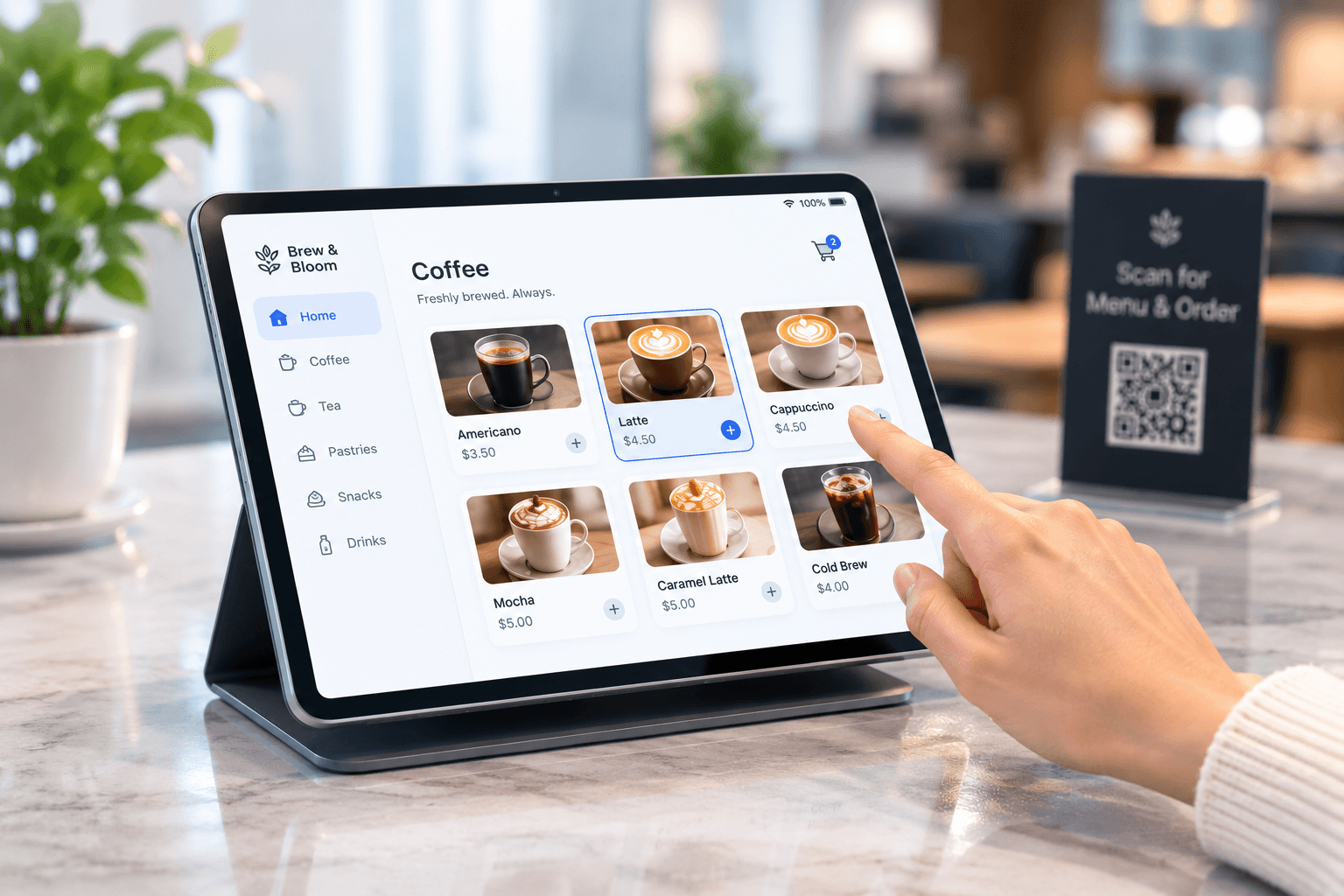 A hand choosing a latte on a tablet menu at a coffee counter.